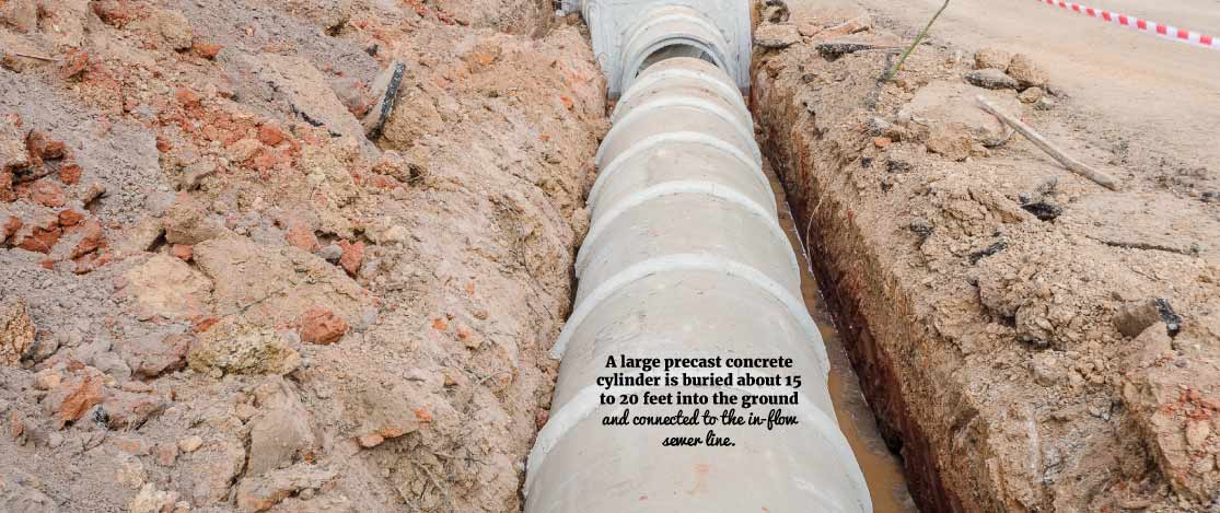 Large precast concrete cylinder buried in the ground.